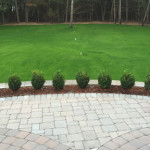 Hardscaping: Stone-brick patio lined with mini-shrubs and mulch - Greener Horizon