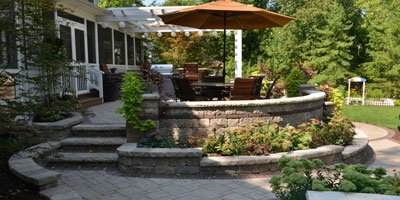 Hardscaping: multi-level stone patio with walls, planting areas, stairs and more - Greener Horizon