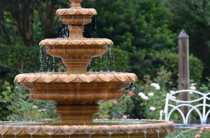 Terracotta four tier water fountain in garden with running water