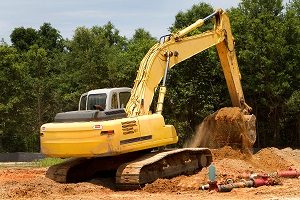 Backhoe machine uses shovel scooper to excavate and move dirt.