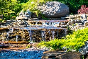 Backyard landscaping with pondless water feature.